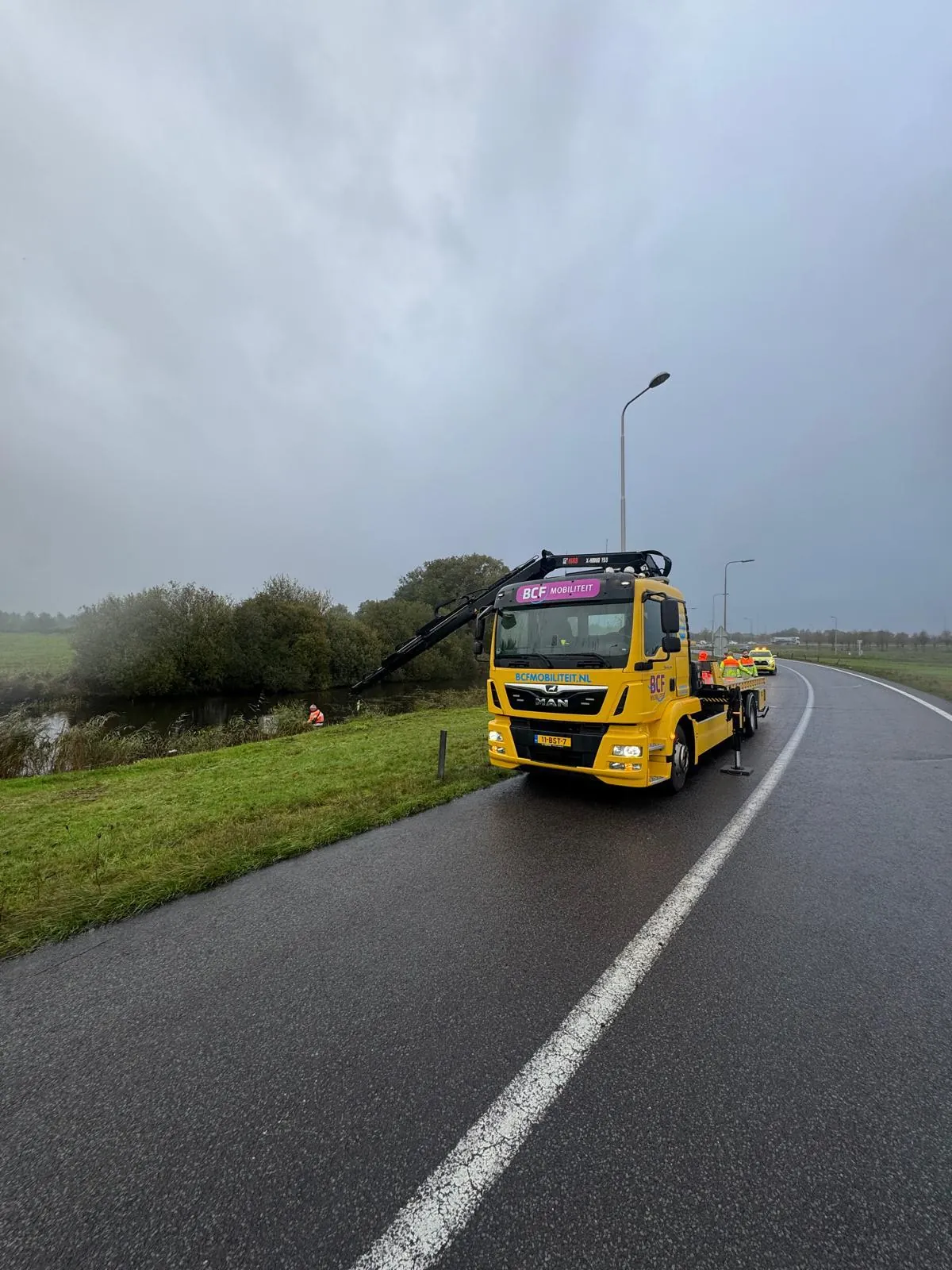 Bergungsfahrzeug mit Kran von BCF Mobiliteit im Einsatz an einem Graben neben der Straße